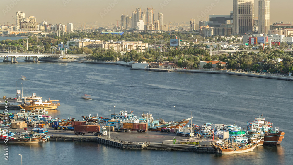 Dubai creek landscape timelapse with boats and ship in port and modern buildings in the background during sunset