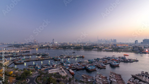 Фотография Dubai creek landscape day to night timelapse with boats and ship near waterfront