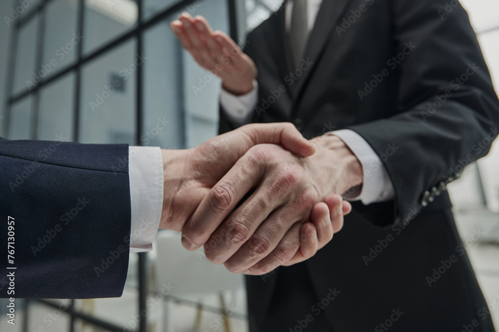 Business partners shaking hands in meeting hall