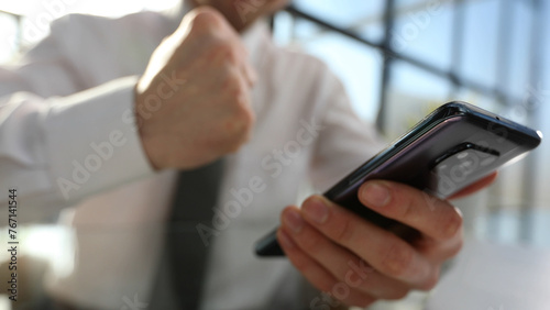 Businessman in close-up in the office at the desk using the phone