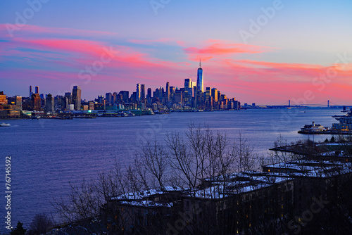 WEEHAWKEN, NJ -18 FEB 2024- Sunset view of the waterfront skyline in Manhattan, New York, seen from across the Hudson River in New Jersey. photo