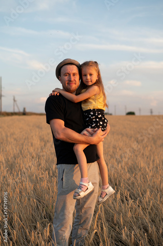 A father holds his daughter in his arms	