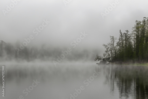 fog on the lake. gloomy foggy long lake with trees, nature concept