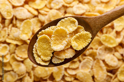 Corn flakes in a wooden spoon background. Top view.