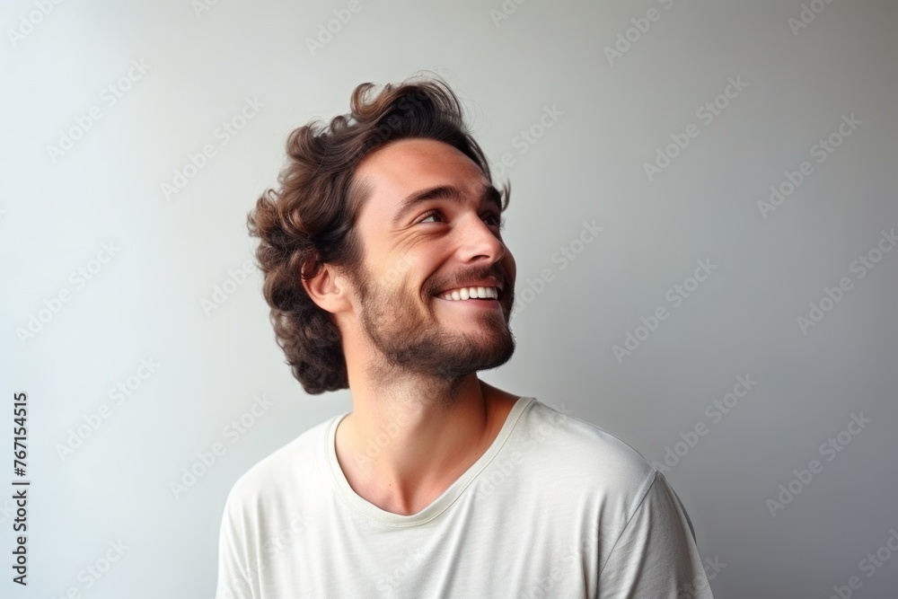 Portrait of a happy young man laughing against a gray background. Portrait of a happy young man laughing against a gray background.