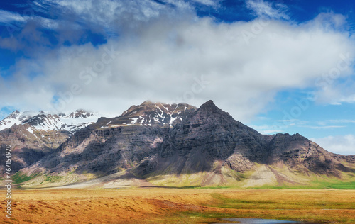 Gentle slopes of snow-capped mountains and glaciers. Wonderful Iceland in the spring.
