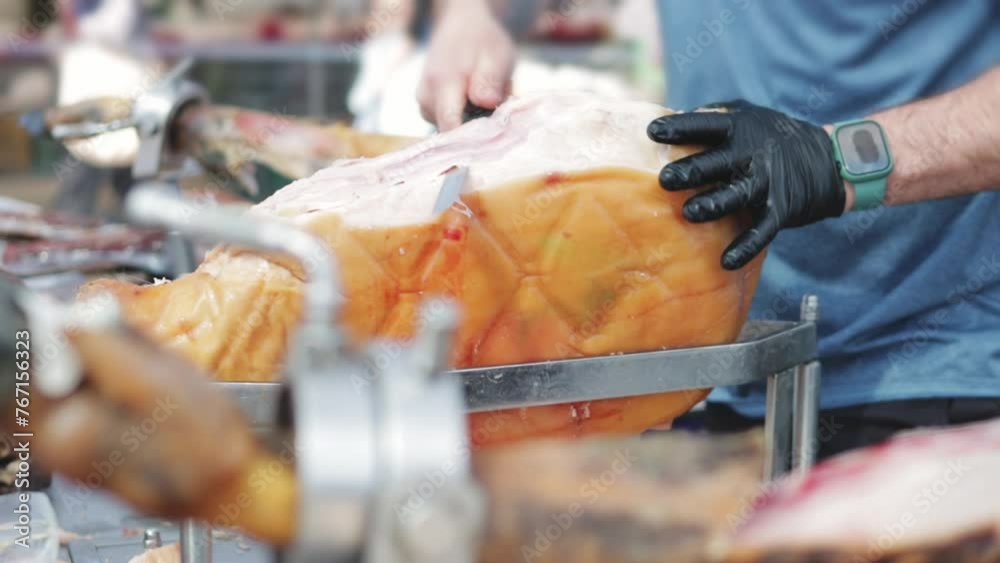 Farmer market in Spain, vendor skillfully carves slices from leg of jamón (smoked ham), demonstrat skill and culinary traditions of Spanish cuisine. Farmer market in Spain, vendor skillfully carves slices from leg of jamón (smoked ham), demonstrat skill and culinary traditions of Spanish cuisine.