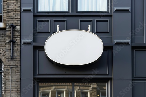 Empty oval store sign on a stylish dark facade
