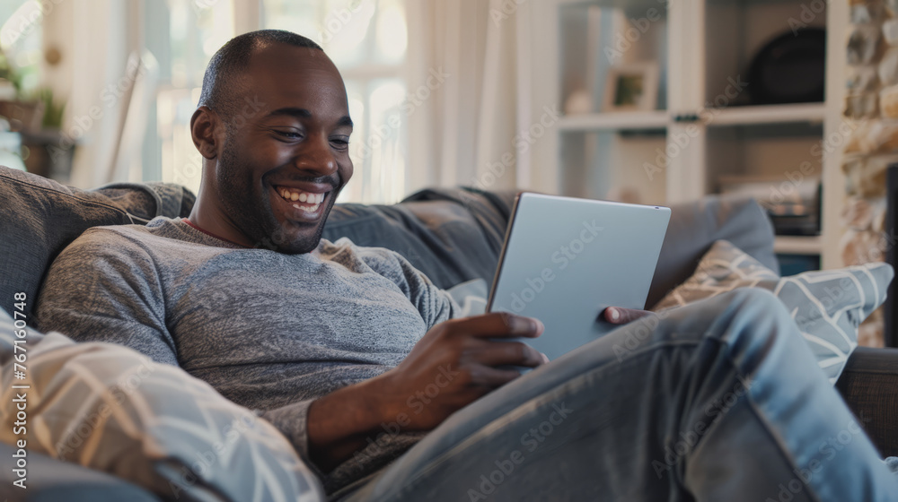 Stylish, modern man smiling at camera and using a tablet in his hands. Stylish, modern man smiling at camera and using a tablet in his hands.