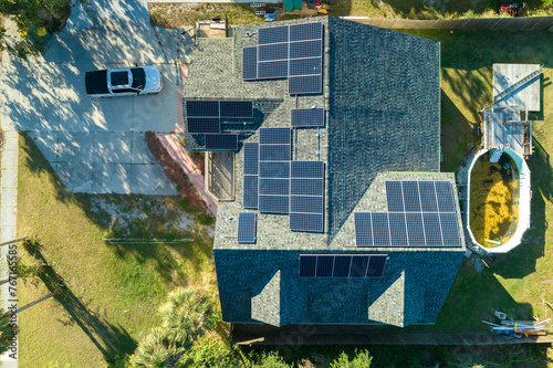 Aerial view of typical american building roof with rows of blue solar photovoltaic panels for producing clean ecological electric energy. Renewable electricity with zero emission concept © bilanol