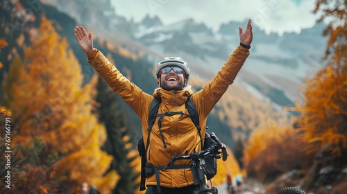 Ecstatic male tourist celebrating his outdoor adventure on a mountainside trail in the fall season