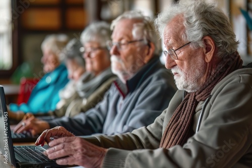 Group of elderly people attending an online course, taking notes on laptops in a community center photo