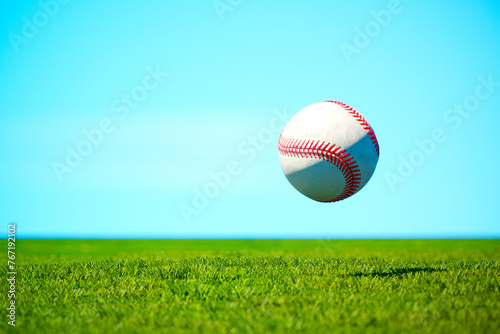 Close-Up of a Baseball Suspended Midair Over a Vibrant Grass Field