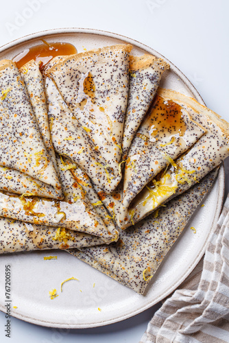 Crepes with poppy seeds, maple syrup and zest. photo