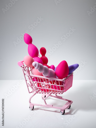 anal plugs and dildo sex toys in shopping basket isolated on white background