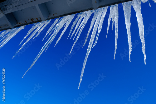 Icicles Hanging from Roof in Winter Blue Sky