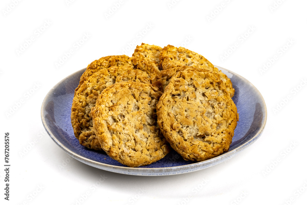 A blue plate filled with tasty oatmeal cookies isolated on white