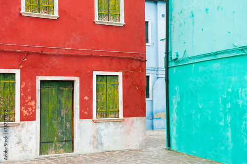 Colorful architecture in Burano island, Venice, Italy. Red and blue painted houses © smallredgirl