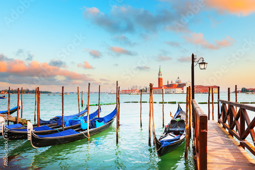 Gondolas on the Grand canal at sunset in Venice, Italy. San Giorgio Maggiore Cathedral in the background. © smallredgirl