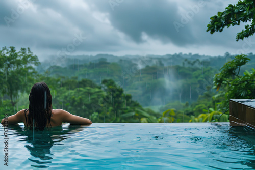 woman relaxing in infinity pool with view of rain forest © Sergio