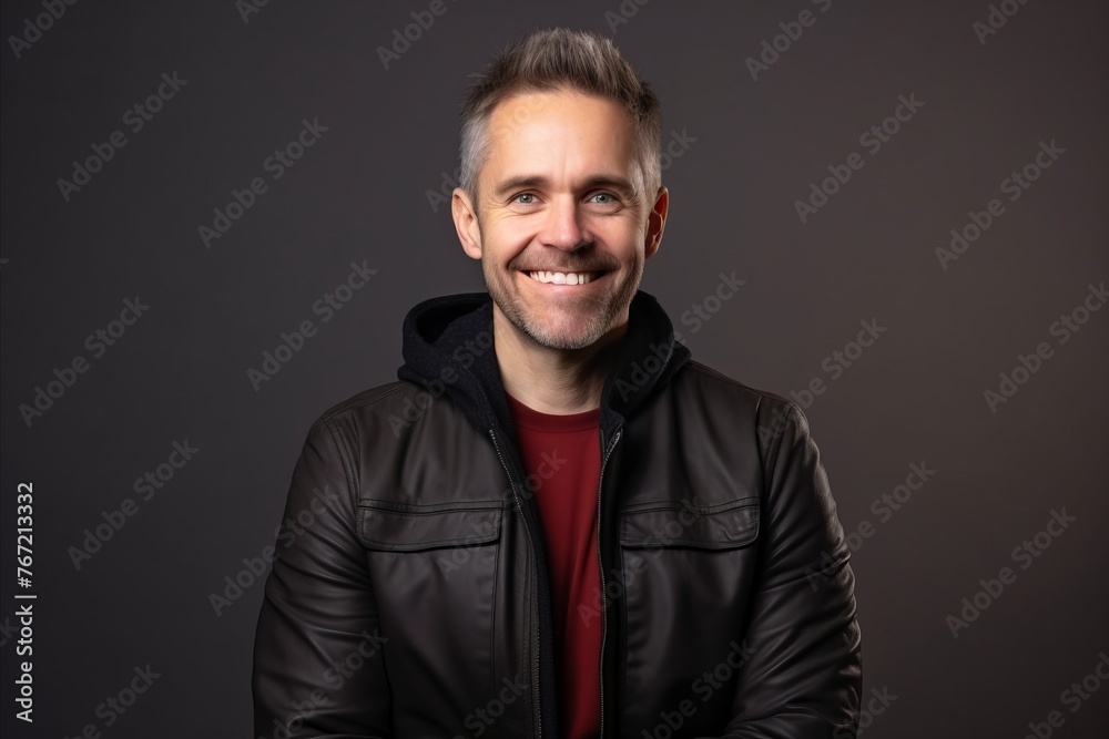 Portrait of a happy middle aged man in a leather jacket.