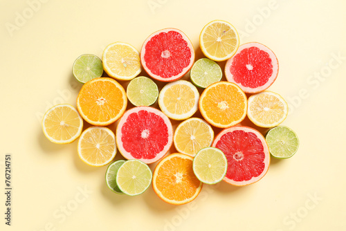 Different cut citrus fruits on beige table  flat lay