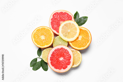 Different cut citrus fruits and leaves on white table  flat lay