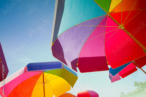 Vibrant, Multicolored Beach Umbrellas Under a Sunny Blue Sky photo