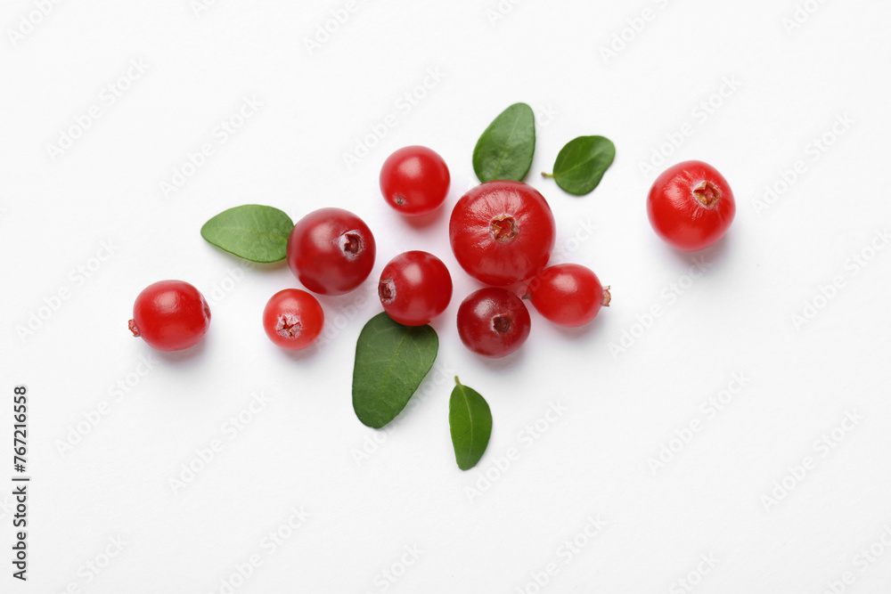Fresh ripe cranberries and green leaves on white background, flat lay Fresh ripe cranberries and green leaves on white background, flat lay
