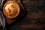 homemade traditional australian meat pie on wooden cutting board, top view, copy space for text 
