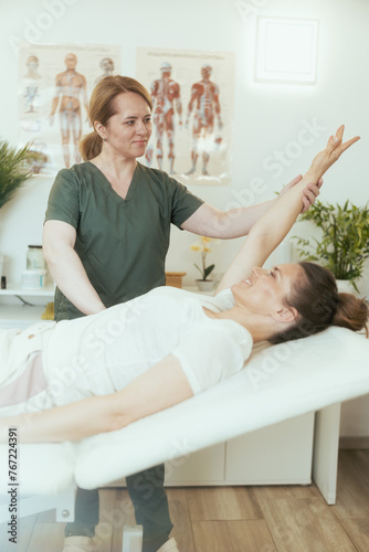 female therapist in massage cabinet conducting examination