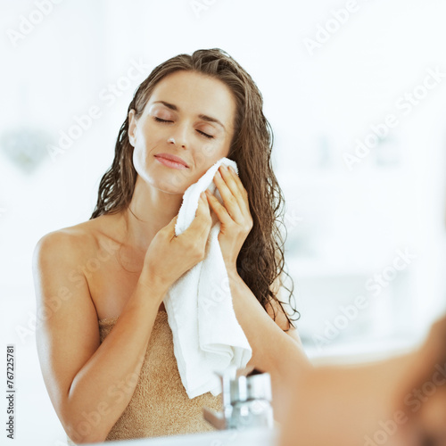 Young woman wiping with towel in bathroom