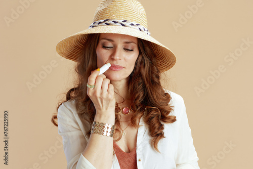 smiling stylish woman in blouse and shorts on beige