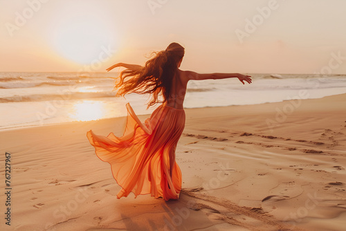 A beautiful young girl in a yellow dress dancing on the beach. The concept of a good mood, vacation, seaside vacation. photo
