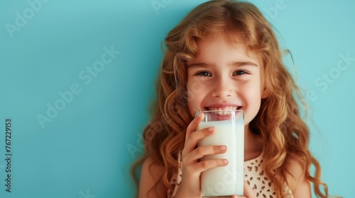 Tranquil girl enjoying a cool glass of milk in a spacious room