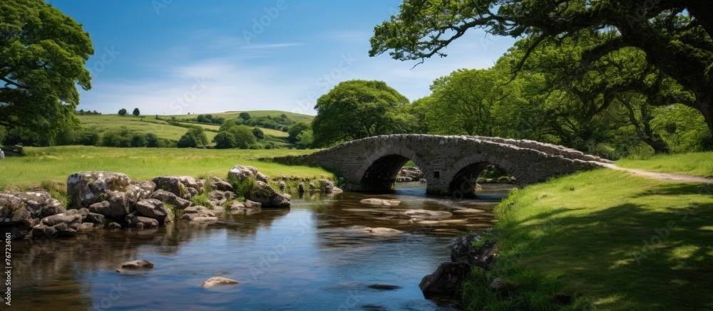 Stone bridge over stream in lush green field Stone bridge over stream in lush green field