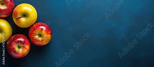 Five apples on blue surface