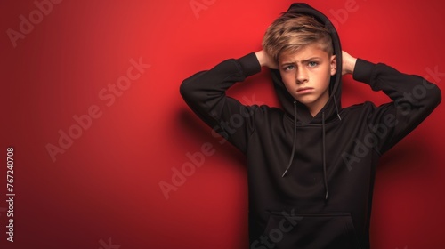 Stressed angry teenage boy on drammatic isolated studio red background. Depression, loneliness, fami photo