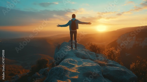 Man with arms wide open facing sunrise photo