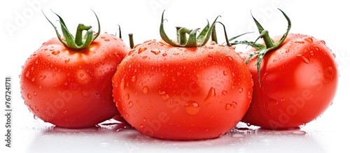 Fresh red tomatoes covered in water drops on a white surface © Ilgun