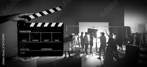 Manipulation images of Movie slate and video production of making of TV commercial movie shoot that film crew team lightman and camera man working together with director and equipment in big studio.