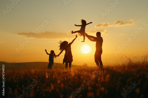 Family lifting child against sunset in the fields