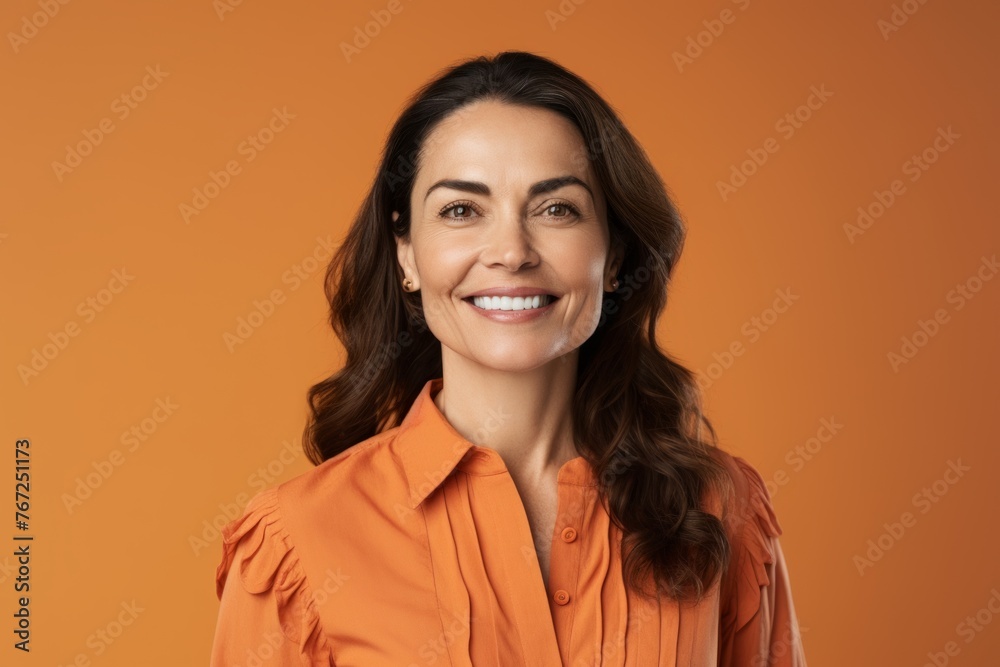 Portrait of smiling businesswoman looking at camera, over orange background Portrait of smiling businesswoman looking at camera, over orange background