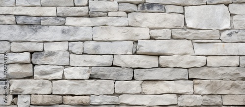 A detailed closeup of a monochrome white brick wall showcasing the rectangle pattern of the building material. The grey tones resemble cobblestone flooring