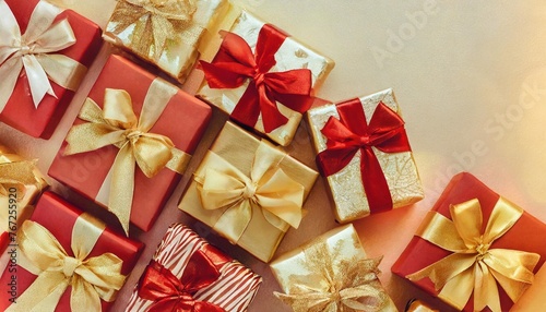 many christmas and new years gifts wrapped in red and golden paper with shiny silk bows top view close up background flat lay isolated pastel background copy space