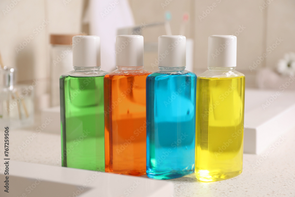 Fresh mouthwashes in bottles on countertop near sink, closeup Fresh mouthwashes in bottles on countertop near sink, closeup