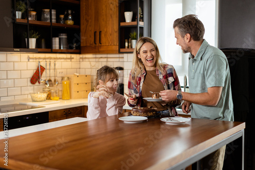 Joyful Family Enjoying Homemade Chocolate Cake in Cozy Kitchen