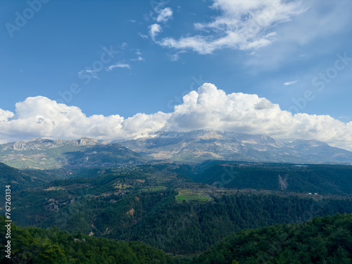 Expansive view featuring the mountain ranges near Köprülü Canyon in Antalya, under a sky with dramatic clouds.