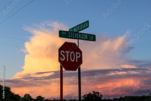 Crossroads and a stop sign in front of a beautiful sunset in the country of Michigan. 