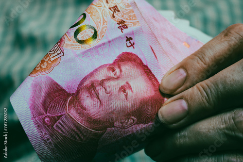 Chinese money in hands, vintage toning. Yuan banknotes, cash.